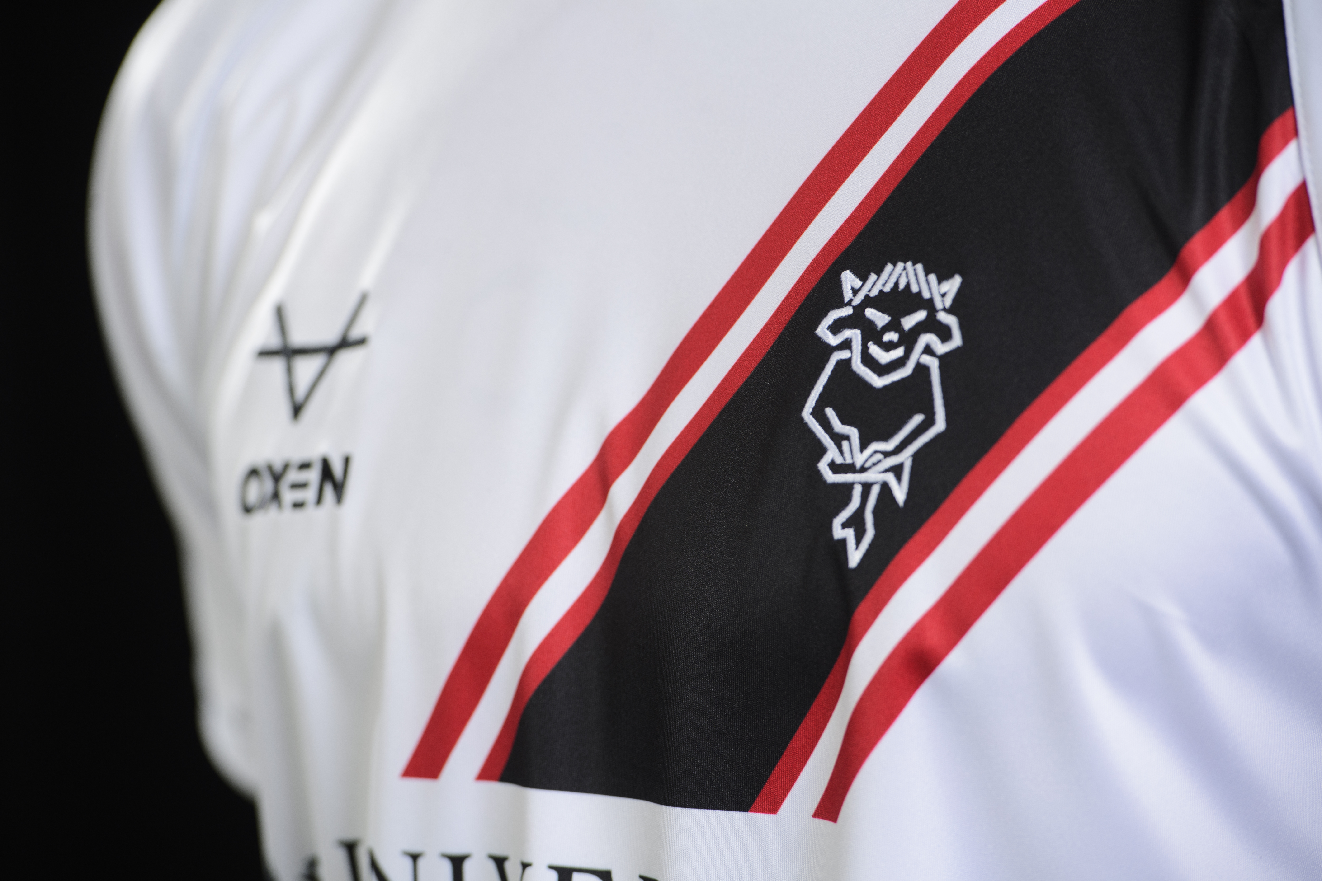 A close up of the front of the 24/25 away shirt design, showing the club badge in white on a black sash