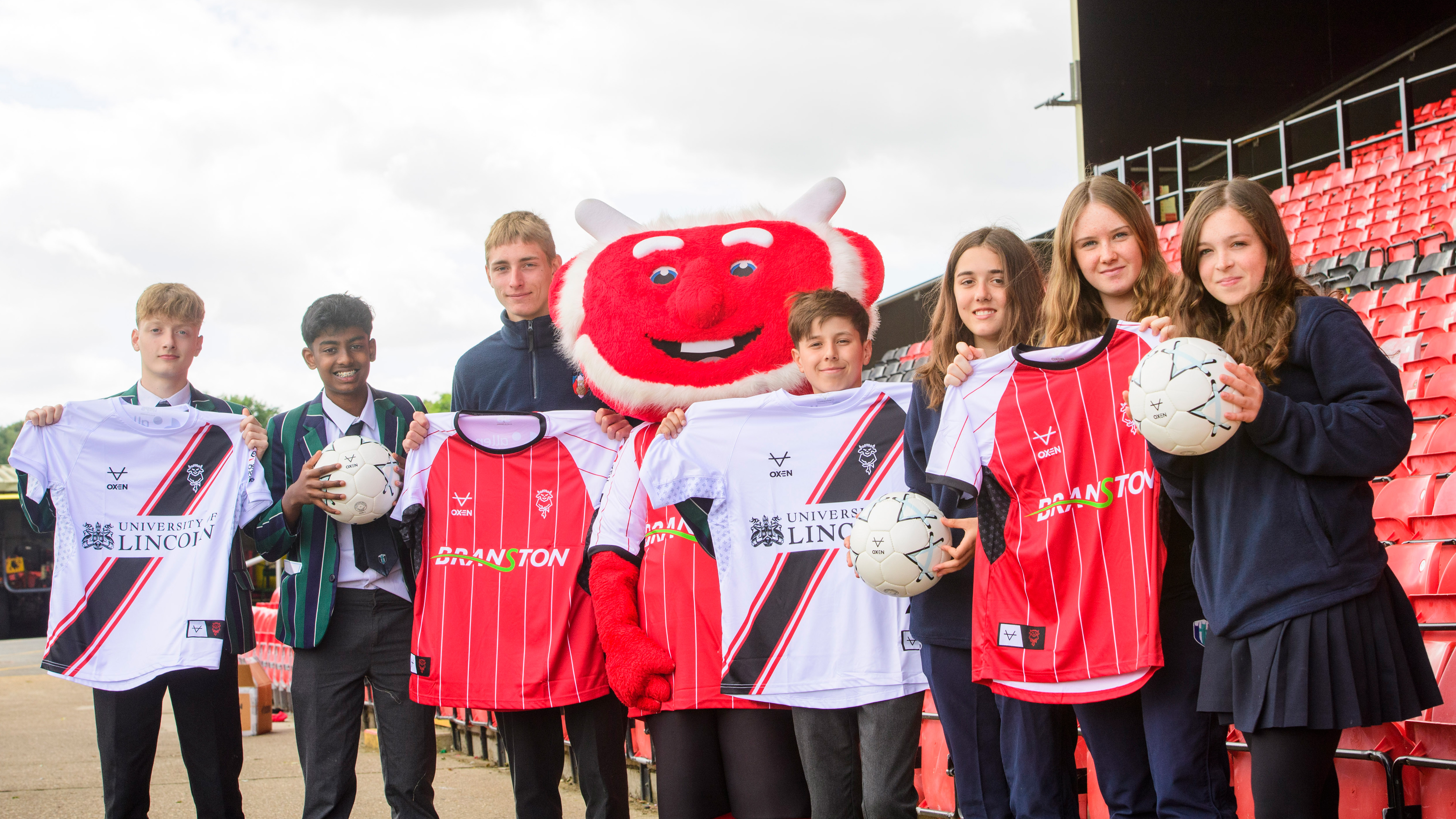 Students from Lincoln Minster pictured with Poacher the Imp after being donated shirts by Lincoln City