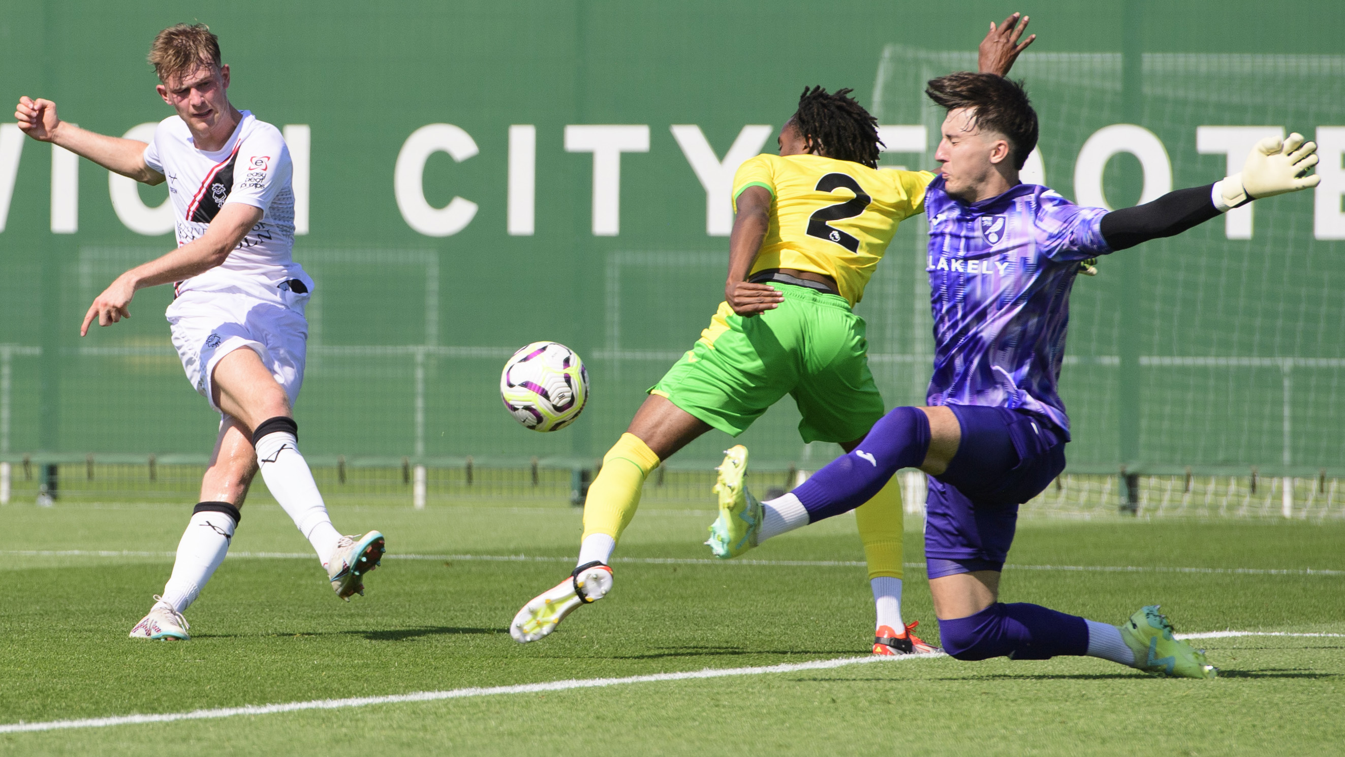 Lincoln City's JJ McKiernan shoots towards goal with his right foot, it is blocked by a combination of a Norwich City defender and their goalkeeper.