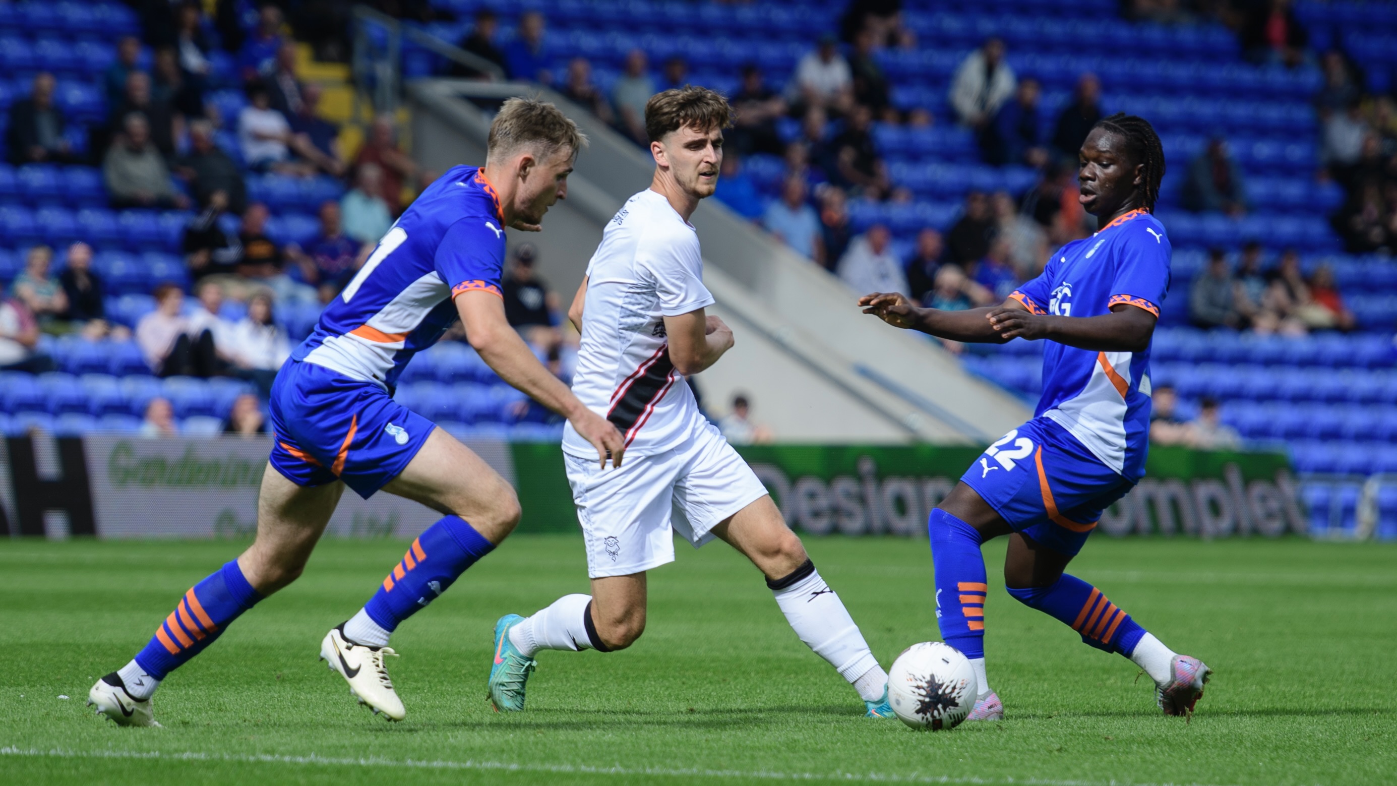 Tom Bayliss fights for possession against Oldham players.