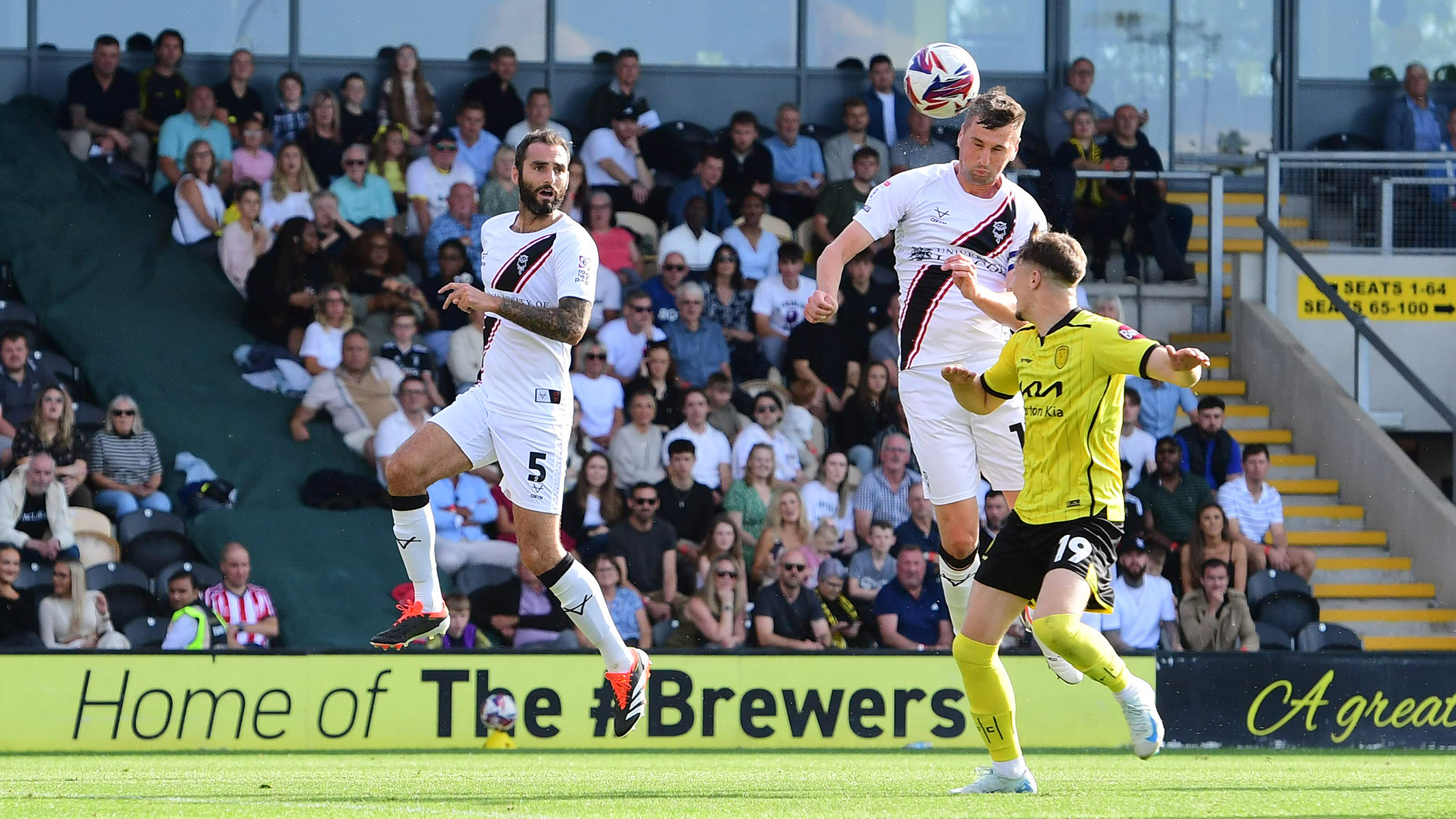 Paudie 'Connor jumps above a Burton player to head the ball and score for Lincoln City.