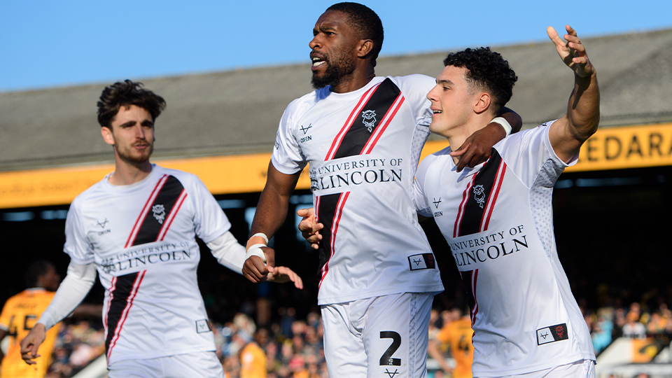 Tom Bayliss, Tendayi Darikwa and Bailey Cadamarteri celebrate the latter's goal at Cambridge United