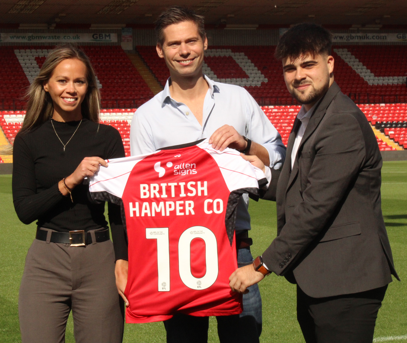 Representatives of the British Hamper Company hold a shirt which reads "British Hamper Co 10"