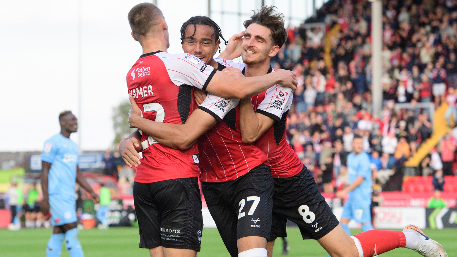 Tom Hamer, Jovon Makama and Tom Bayliss celebrate a goal at the LNER Stadium