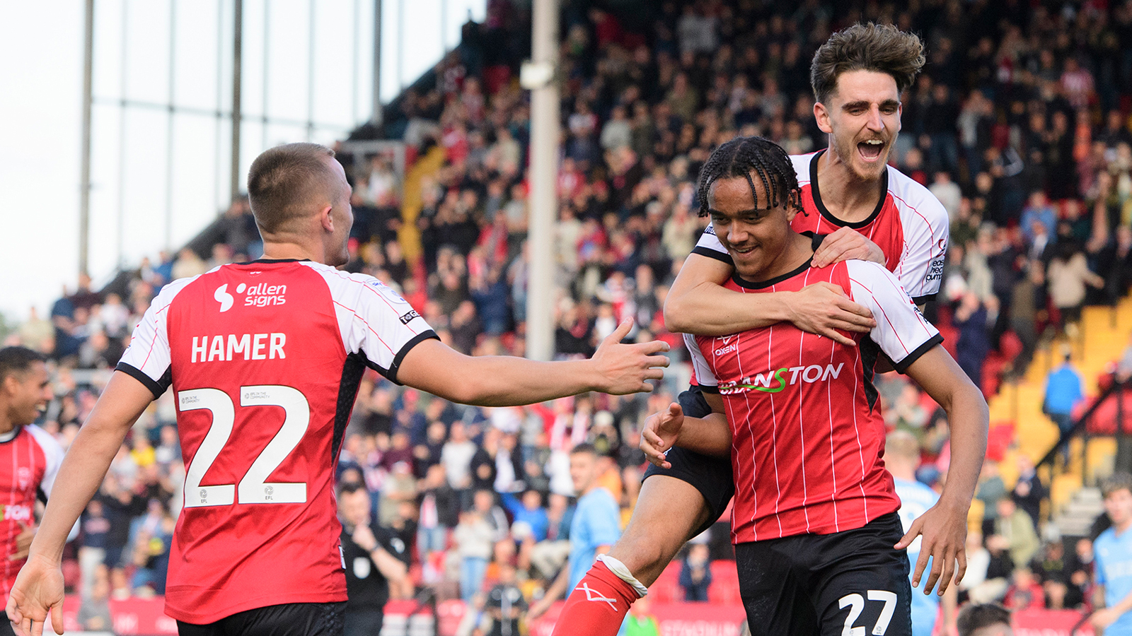 Tom Hamer and Tom Bayliss congratulate Jovon Makama on his goal in City's 2-1 home win against Leyton Orient