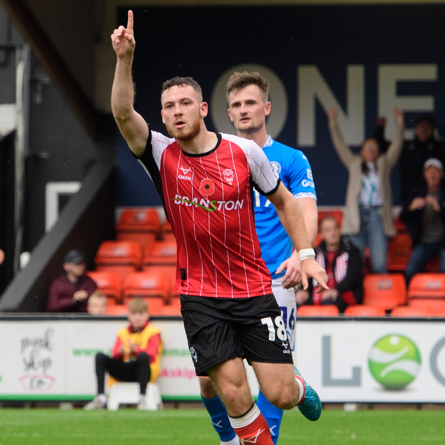 Ben House runs away in celebration of his goal. He is holding his right hand up and pointing.