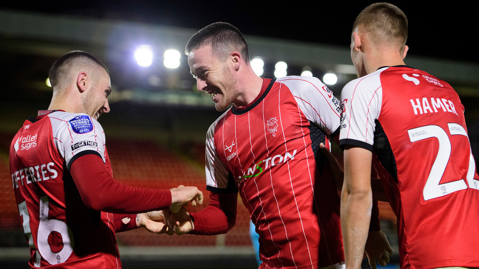 Jack Moylan celebrates scoring the winning goal at Grimsby Town with Dom Jefferies and Tom Hamer