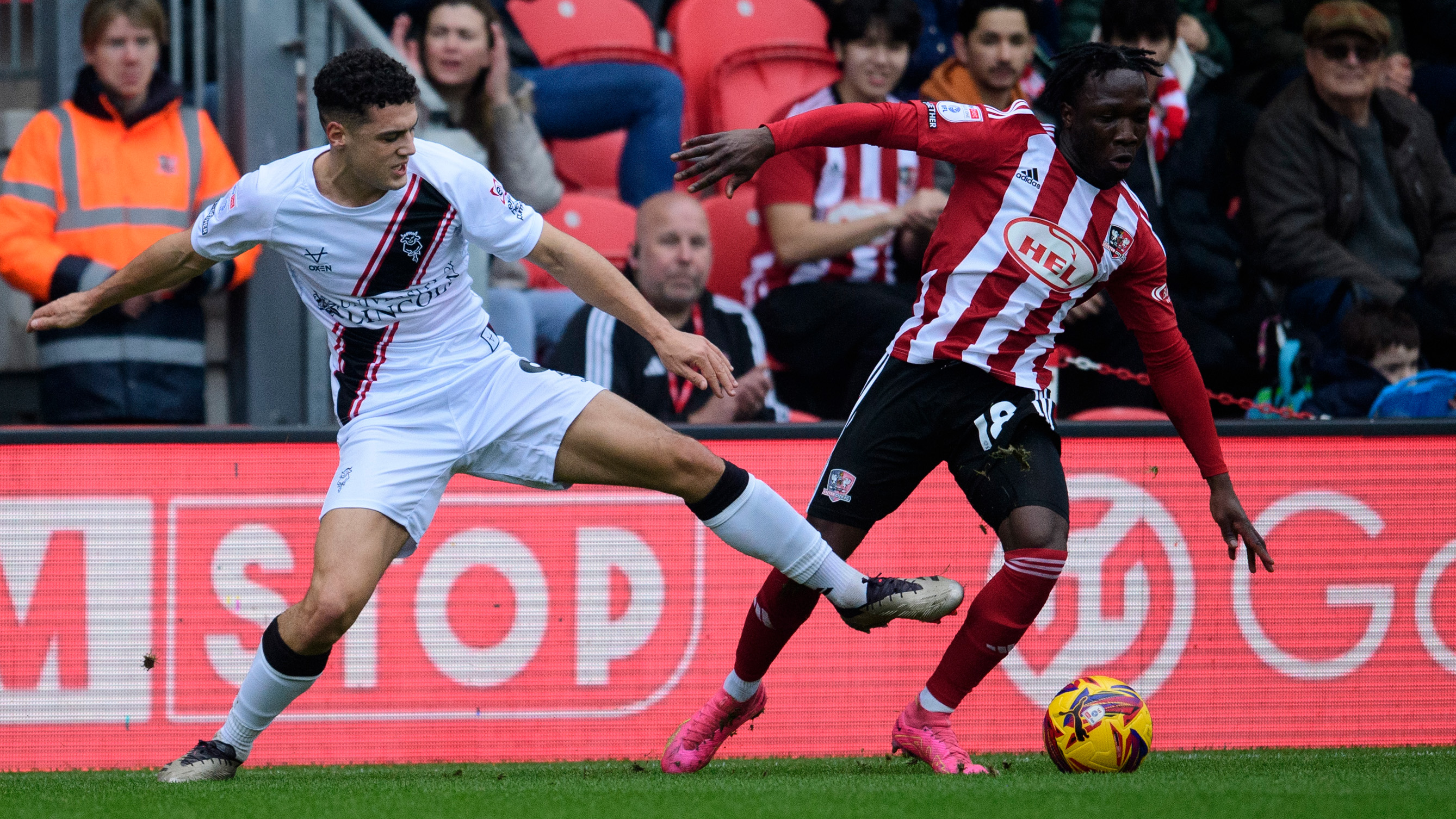 Bailey Cadamarteri challenges for the ball with an Exeter City player.