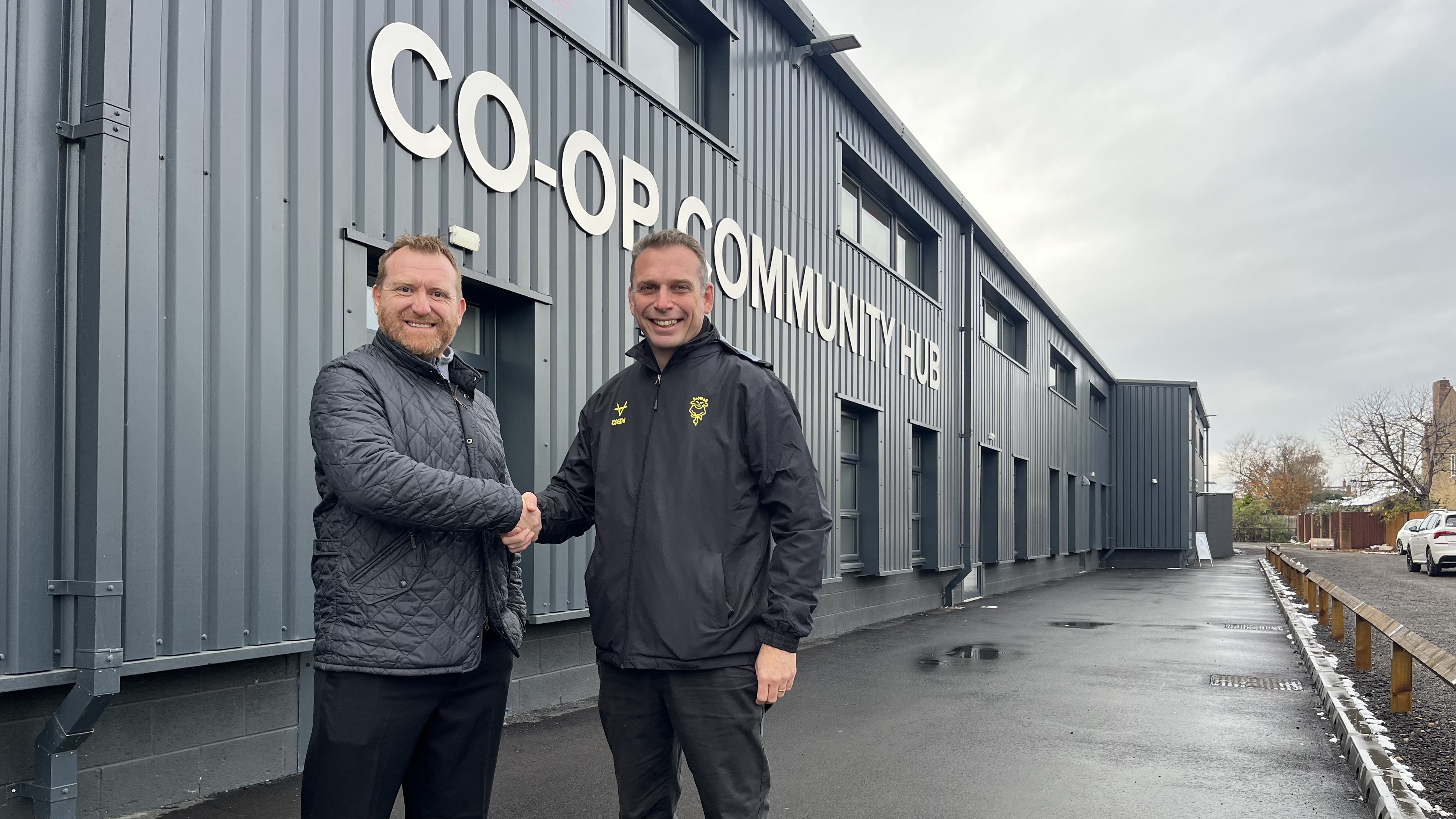 Gary Hutchinson shaking hands with Martin Hickerton in front of the Co-op Community Hub.