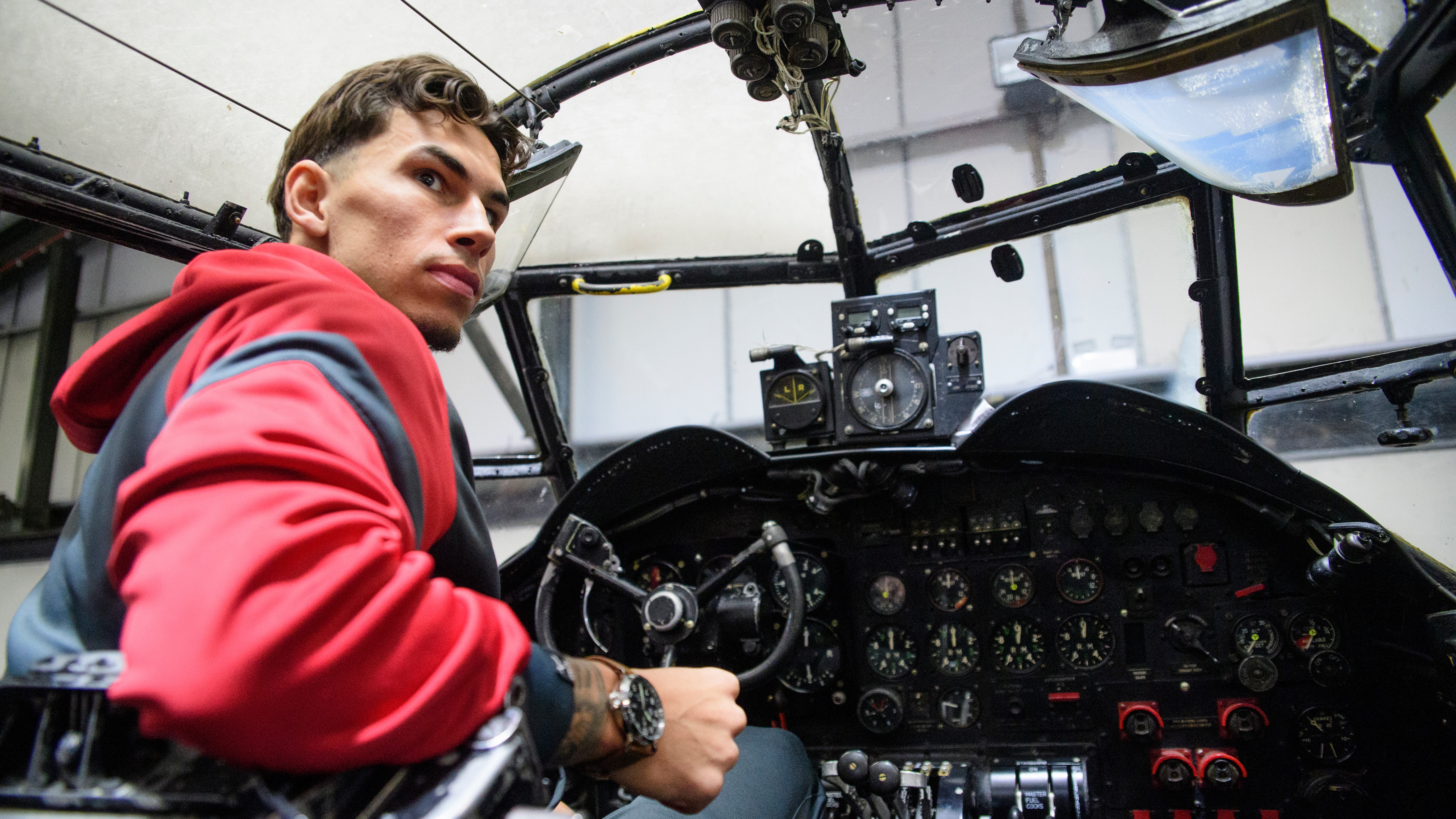 A man sits in the cockpit of a Lancaster bomber. He is wearing the Lincoln City Lancaster watch