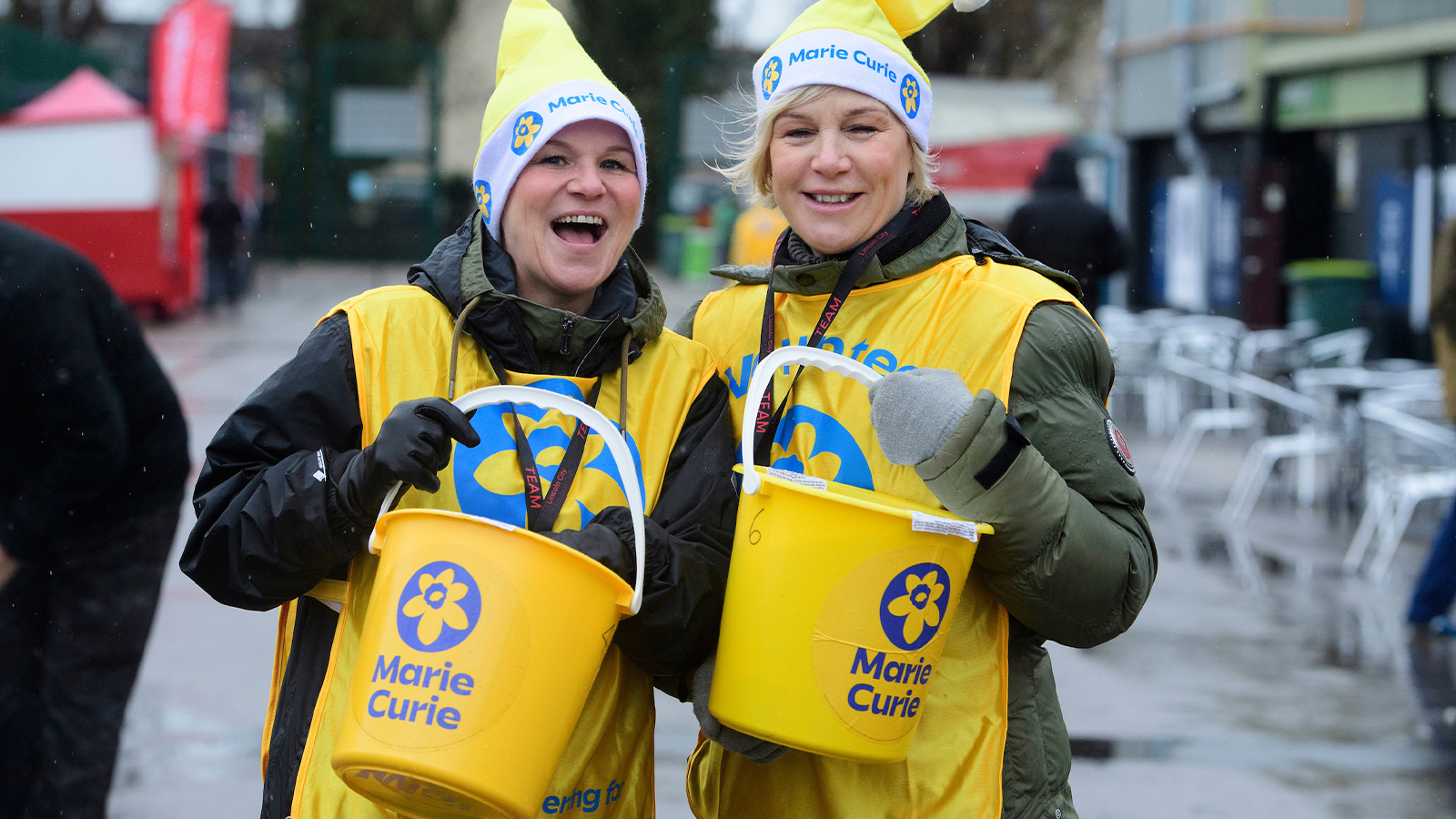 A photo of two charity bucket collectors outside the LNER Stadium