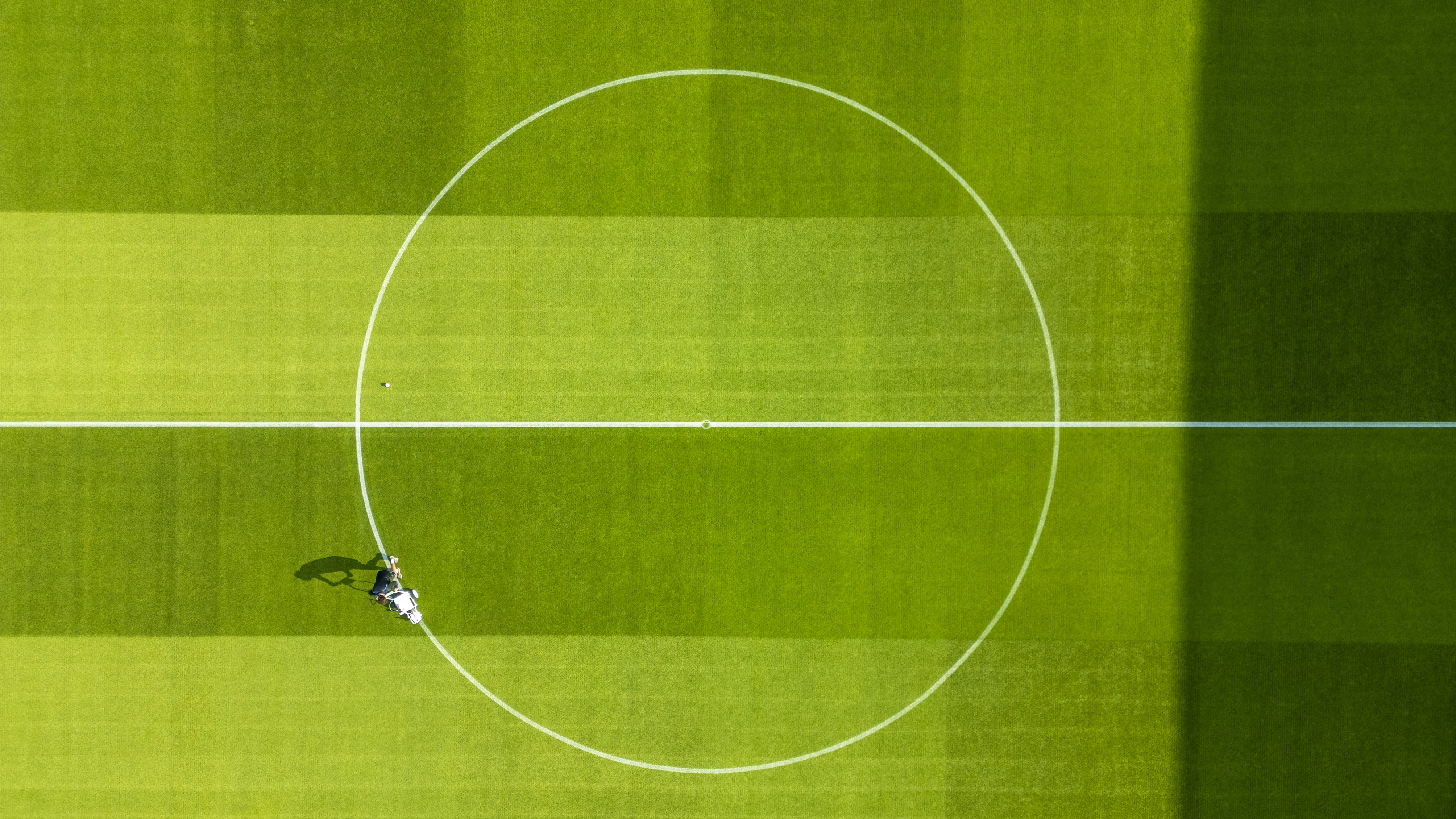 An overhead drone shot of the pitch at the LNER Stadium. It is looking down over the centre circle where a member of the groundstaff is marking out the pitch.