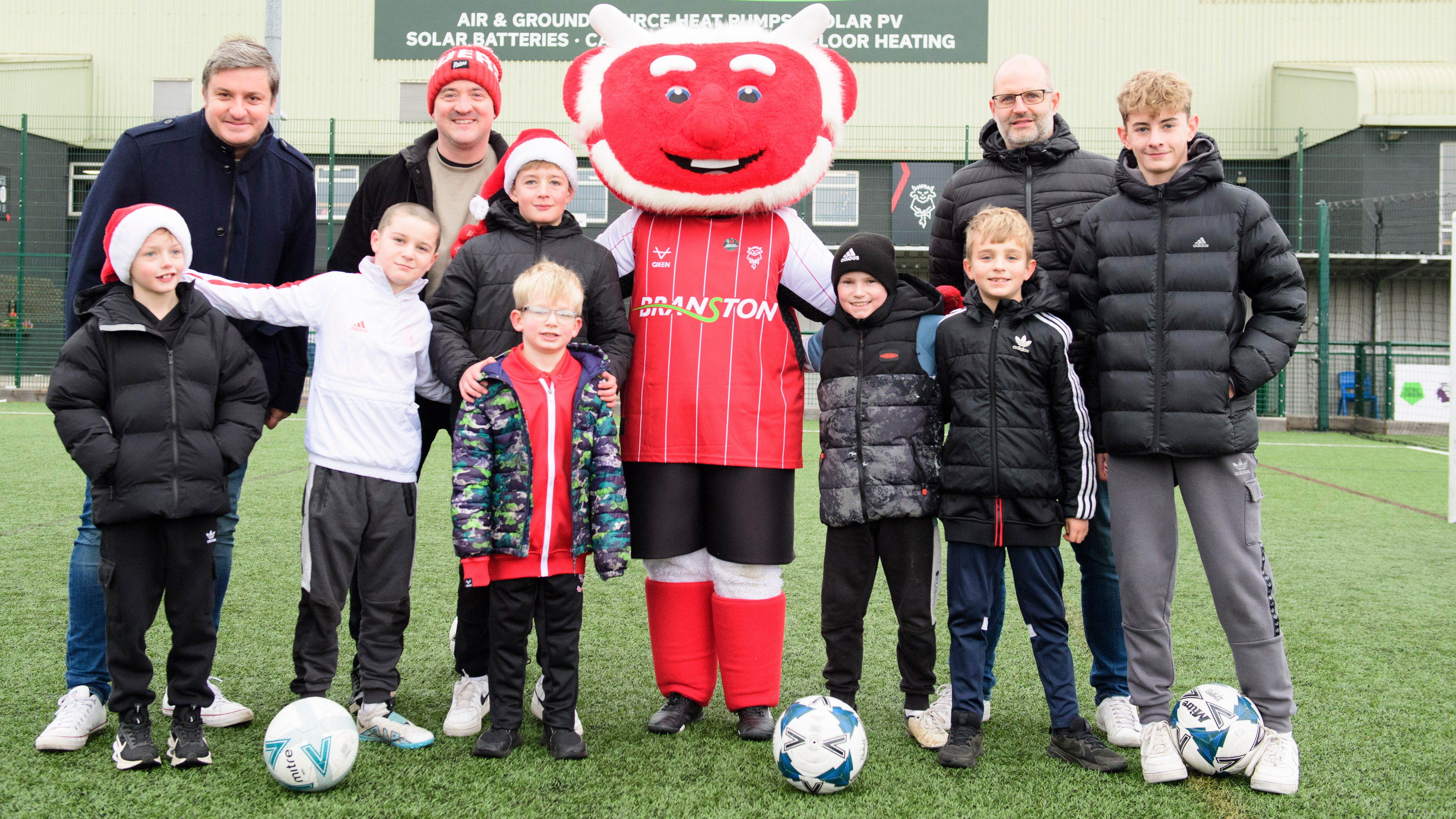 Lincoln City supporters pose in a group with Poacher the Imp 