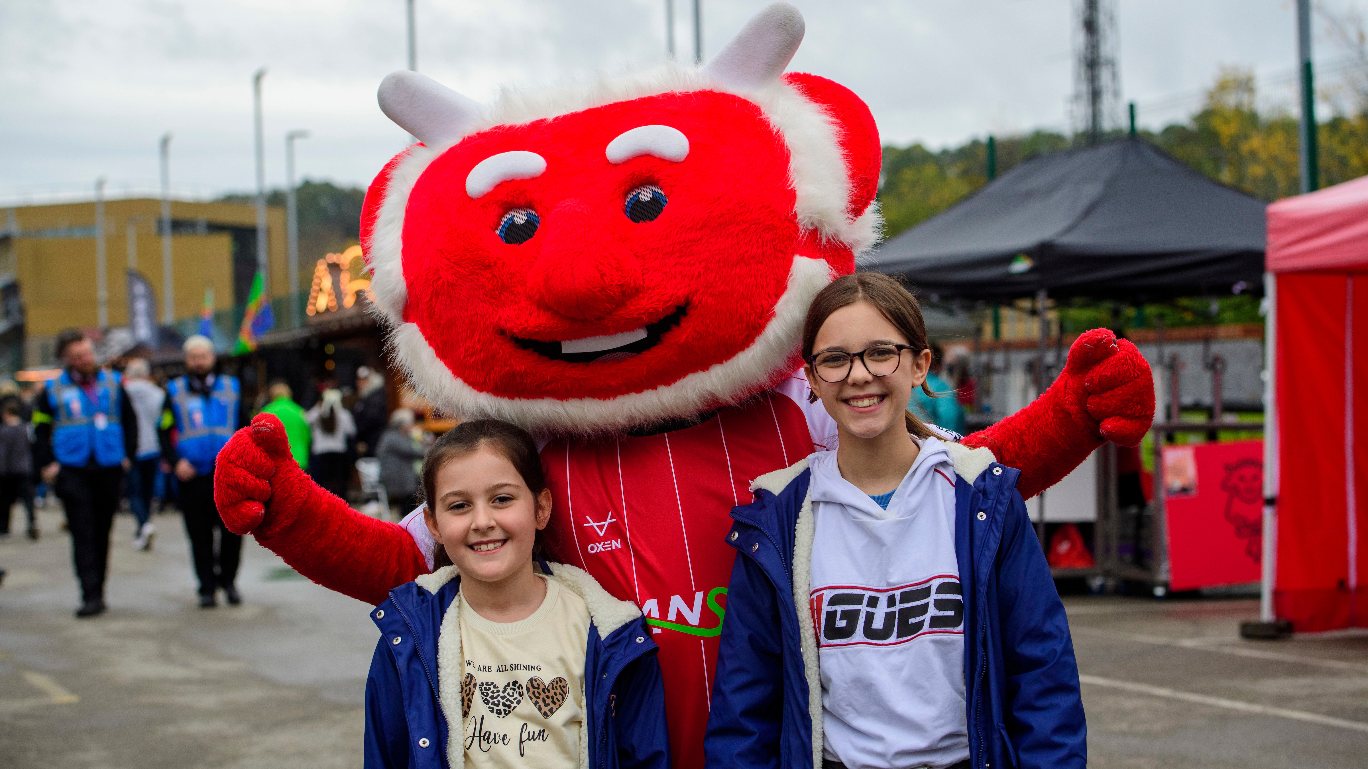 Poacher the Imp poses with his arms around two young girls