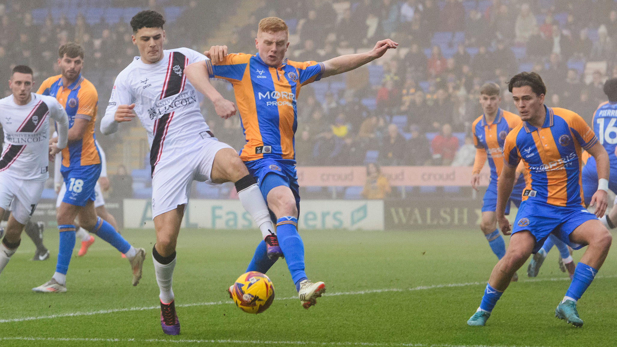 Bailey Cadamarteri challenges for the ball with a Shrewsbury Town player