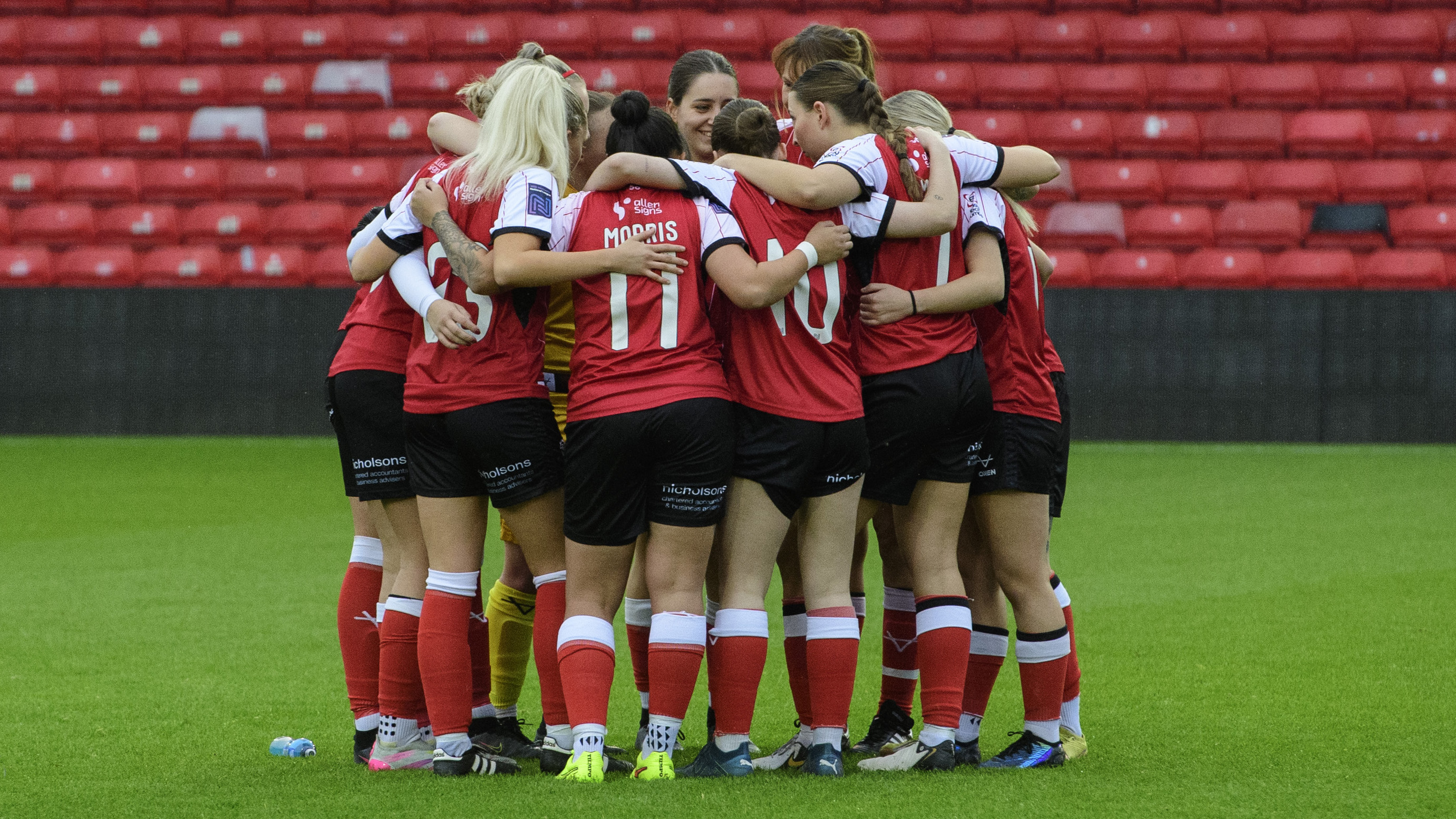 Lincoln City Women players in a pre-match huddle.