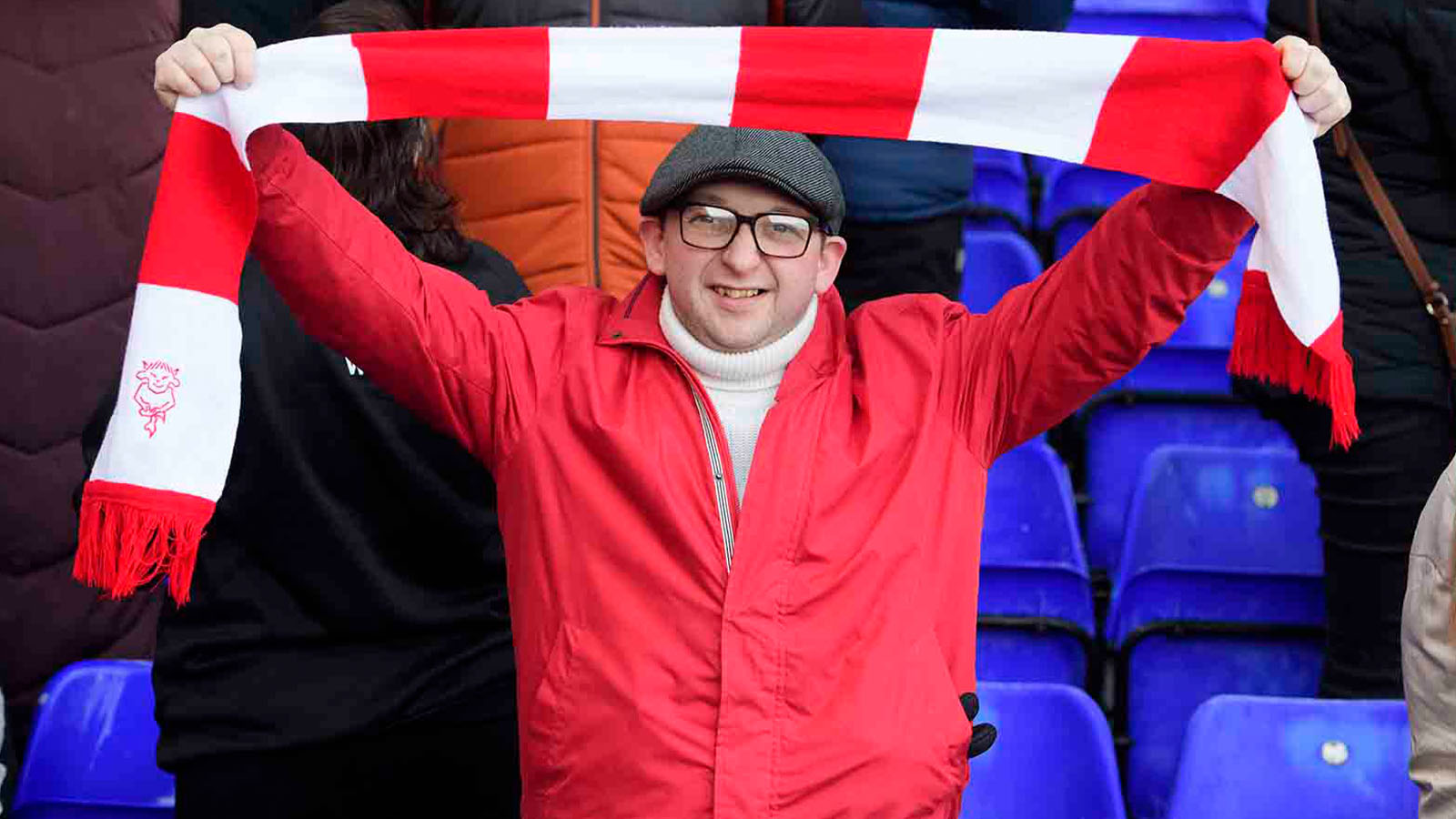 An Imps supporter raises a scarf and gets behind his team at Birmingham