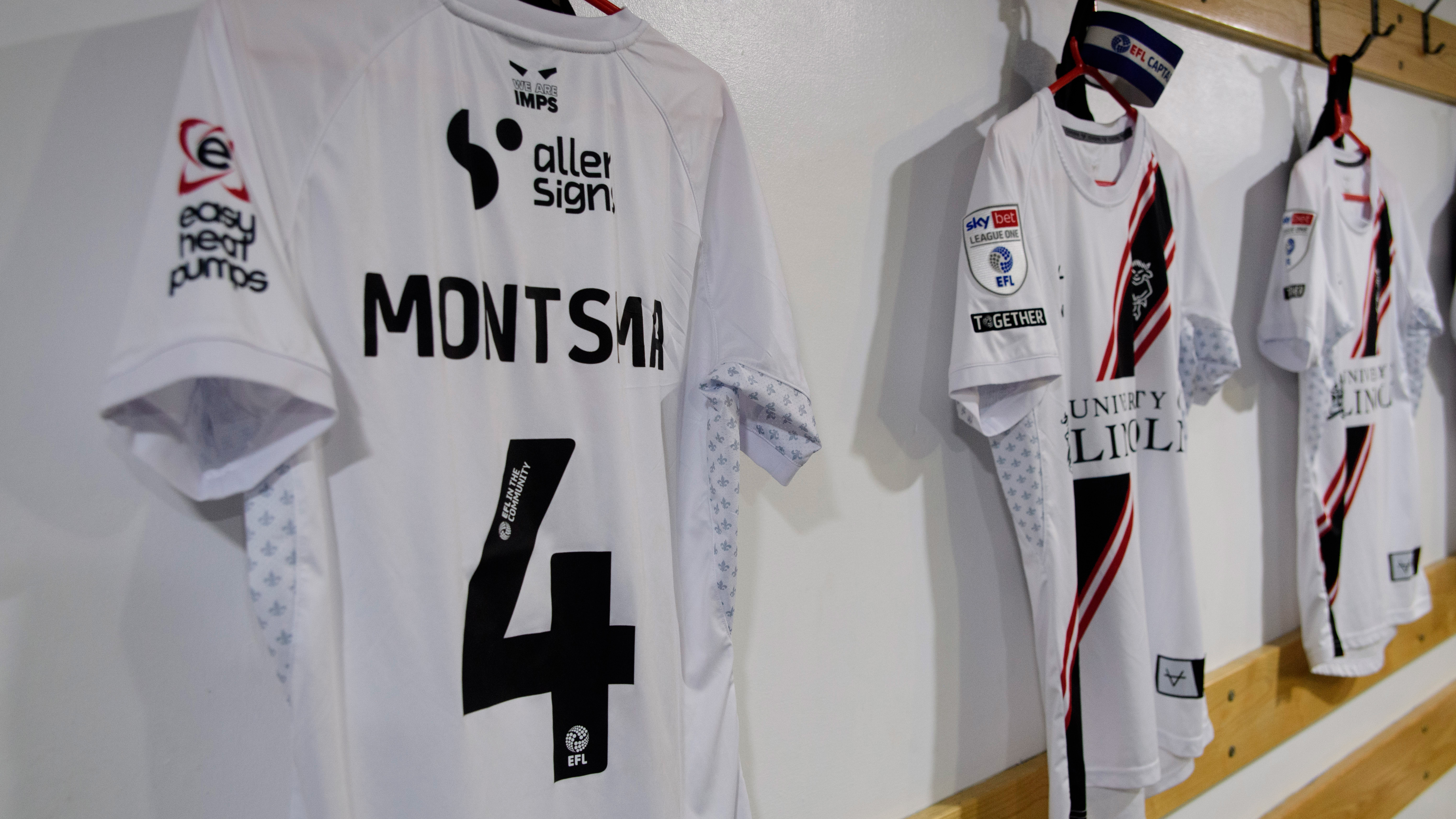 A white shirt hung up in a changing room with Montsma 4 on the back