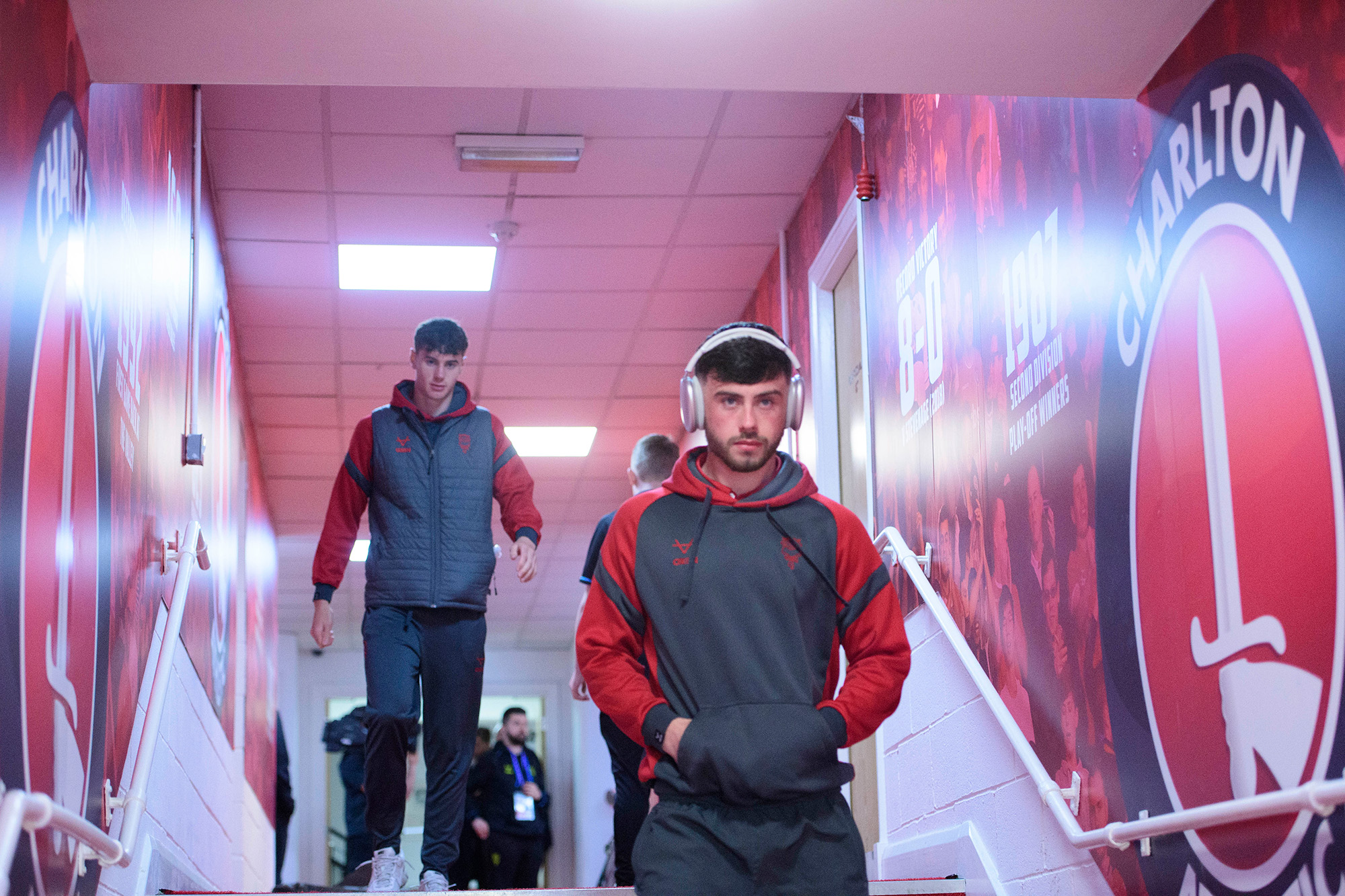 Sean Roughan walks past a wall with a Charlton Athletic badge on it