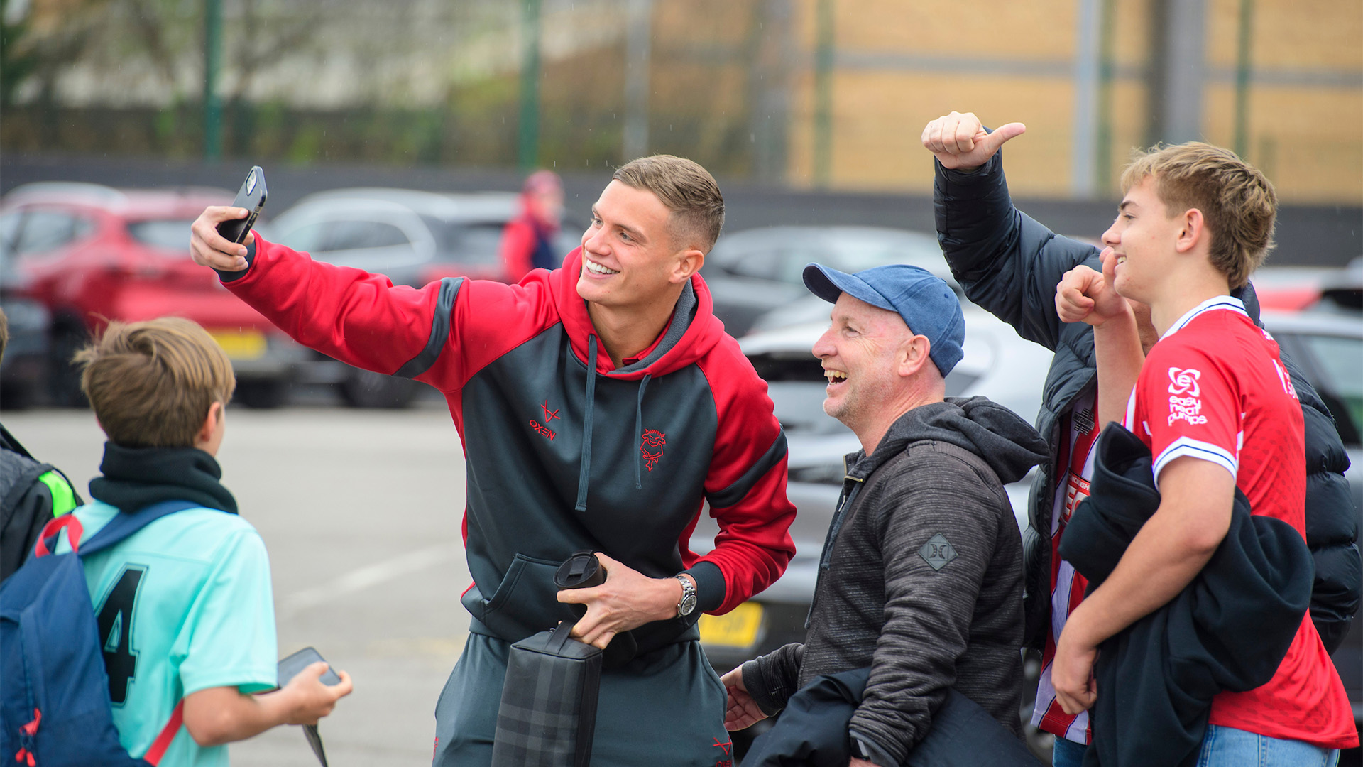 George Wickens taking a selfie with Lincoln City supporters at the LNER Stadium.