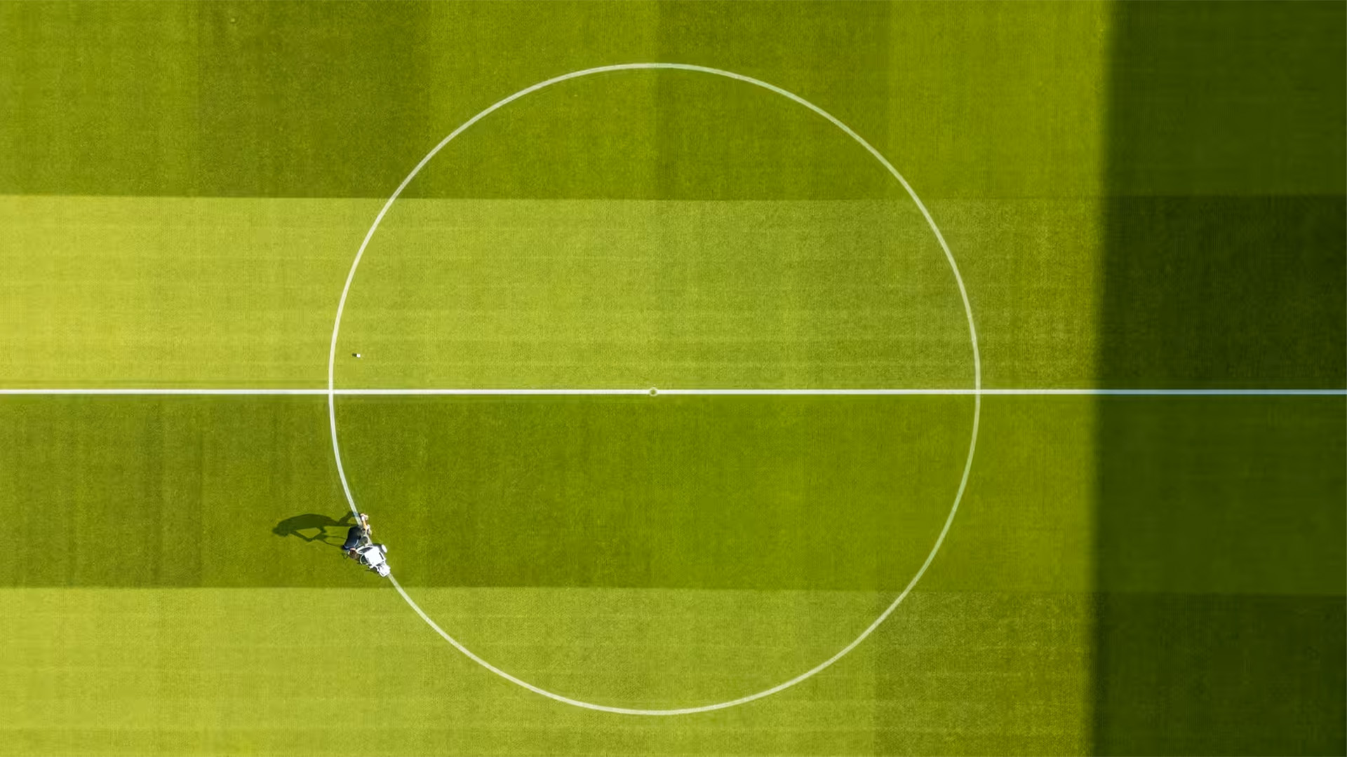 An image of a man doing work on a football pitch taken from a drone.