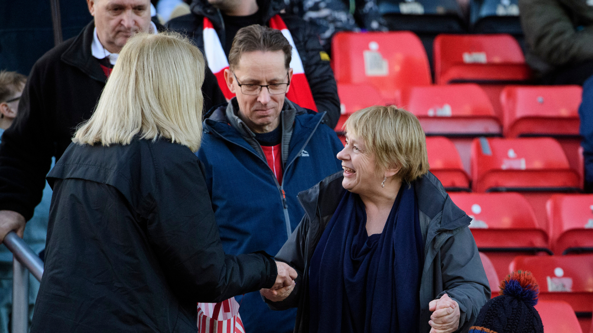 Lincoln City matchday supporter liaison officer (SLO) Libby White hands out sweets to young fans during the EFL Sky Bet League One match between Lincoln City and Burton Albion at LNER Stadium, Lincoln.