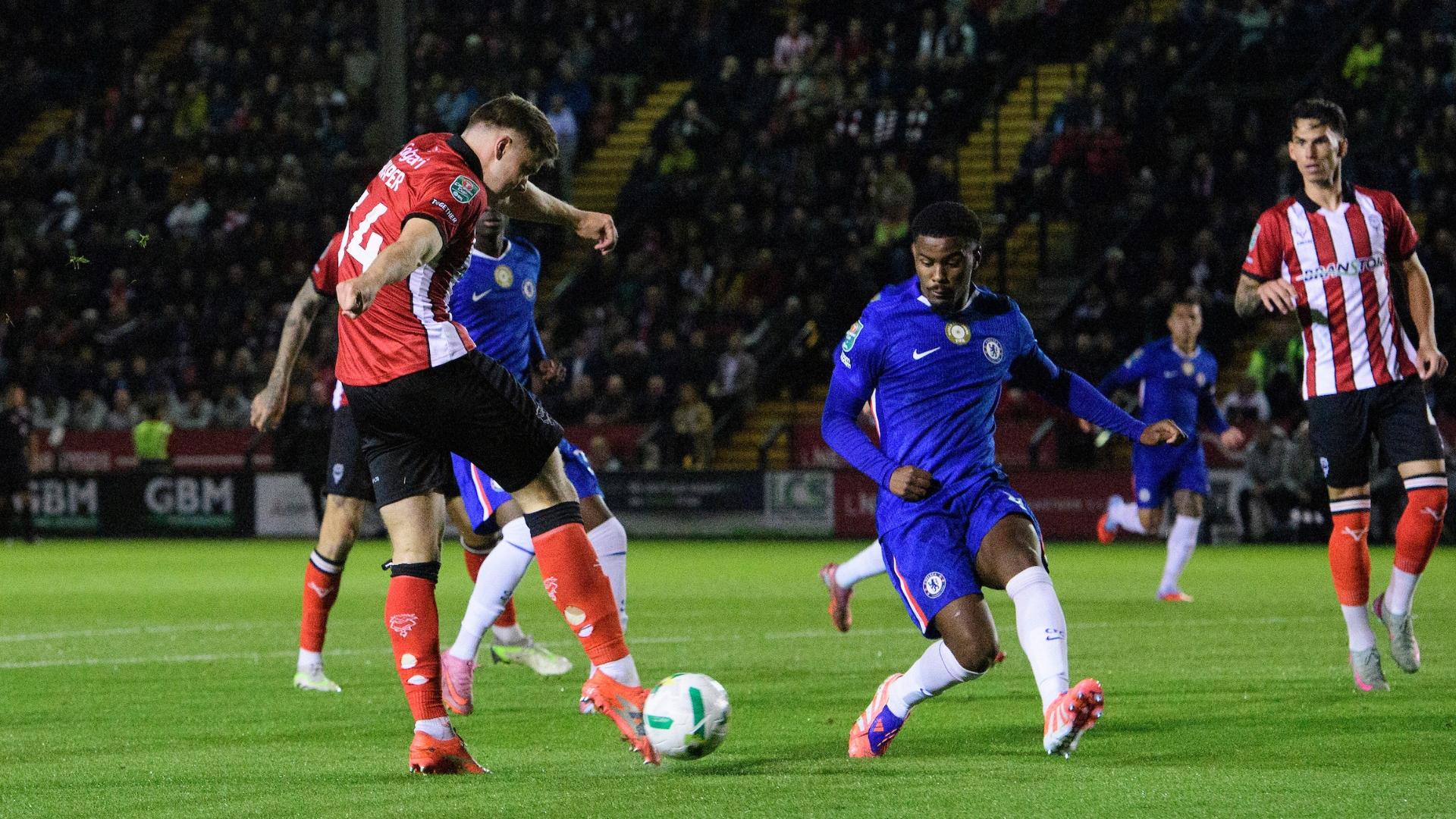 Lewis Montsma of Lincoln City has a shot under pressure from Enzo Fernandez of Chelsea during the Carabao Cup third round match between Lincoln City and Chelsea at LNER Stadium, Lincolnshire.