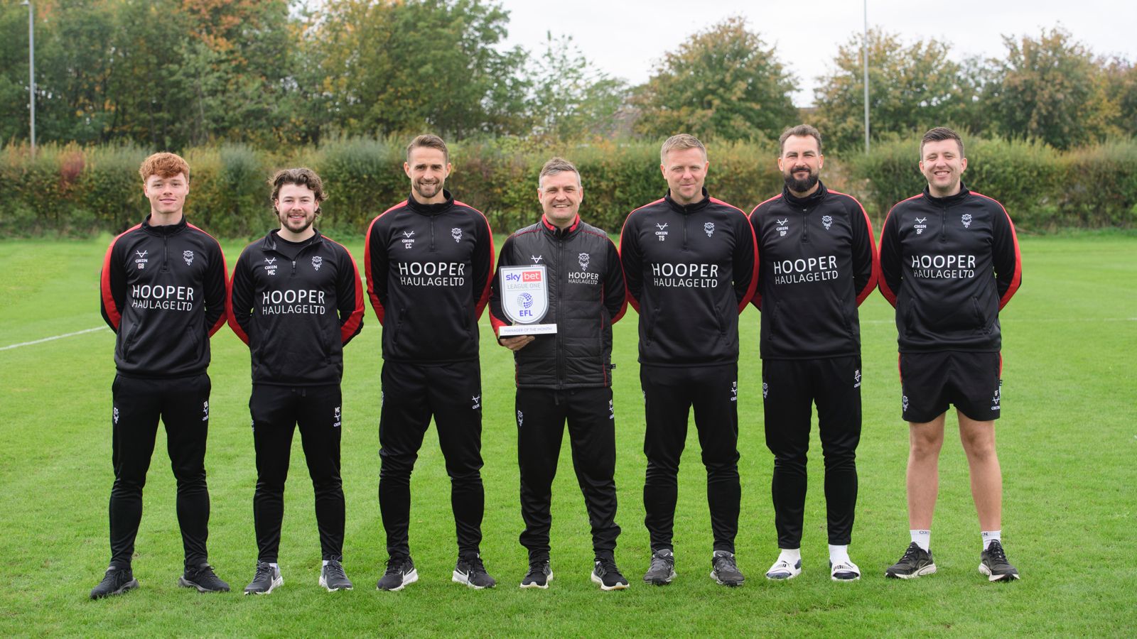 The Lincoln City coaching staff pose with the Sky Bet League One Manager of the Month trophy