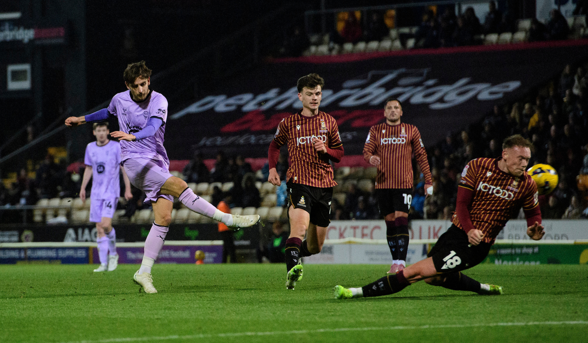 Tom Bayliss of Lincoln City shoots under pressure from Ciaran Kelly of Bradford City during the EFL Sky Bet League One match between Bradford City and Lincoln City at University of Bradford Stadium, Bradford.