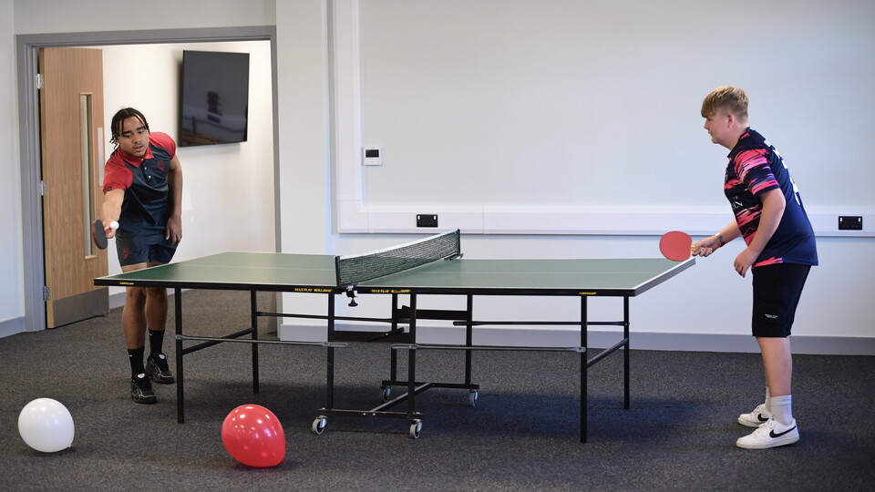 Jovon Makama playing table tennis in the Co-op Community Hub.