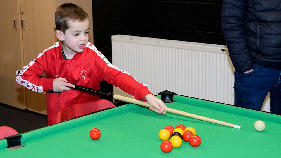 A young Imps fan photographed playing pool in Poacher's Den