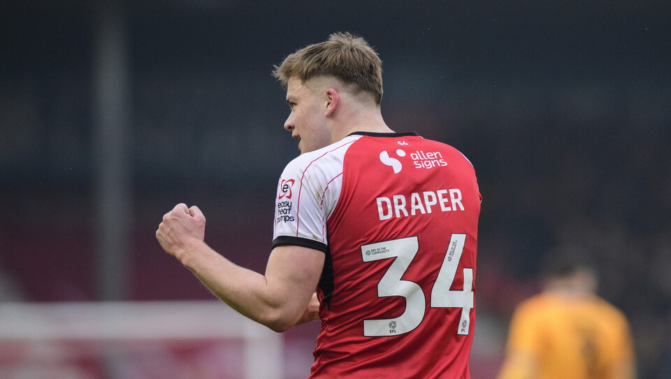 Freddie Draper celebrates scoring a goal. He is pictured from behind with "Draper 34" written in white letters on this red top.