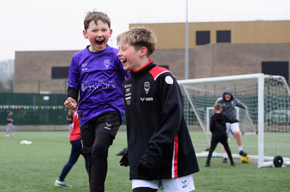 Young fans play football on the 3G pitch ahead of a home match