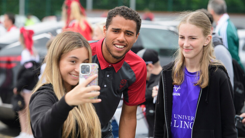 Ethan Erhahon poses for a selfie with young fans outside the LNER Stadium