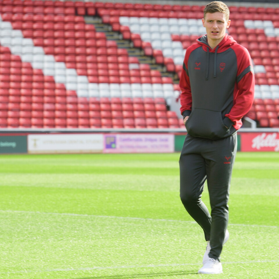 Ethan Hamilton walks on a football pitch