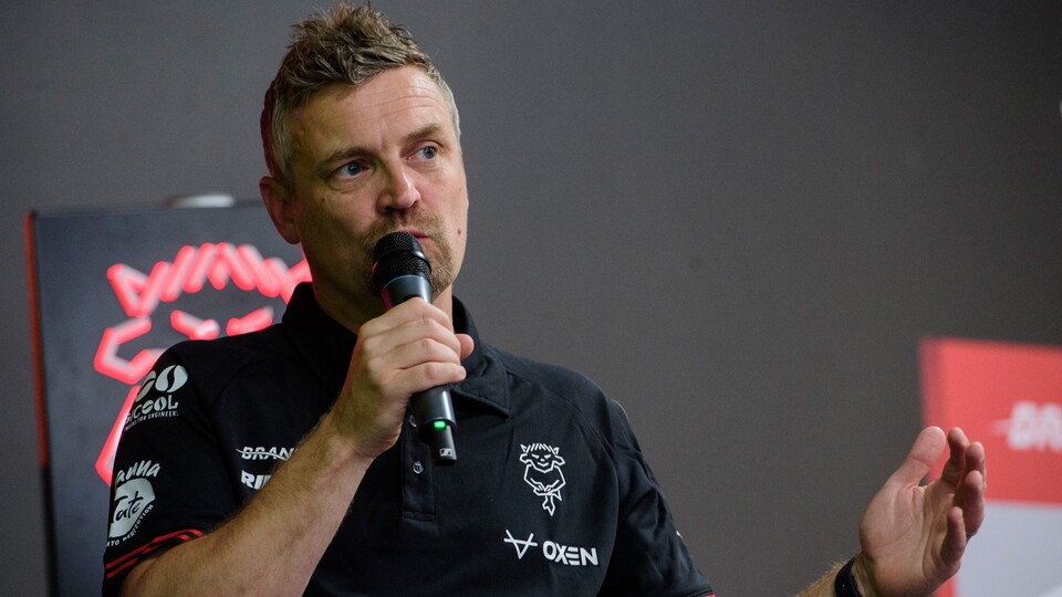 Michael Skubala holds a microphone as he speaks on stage