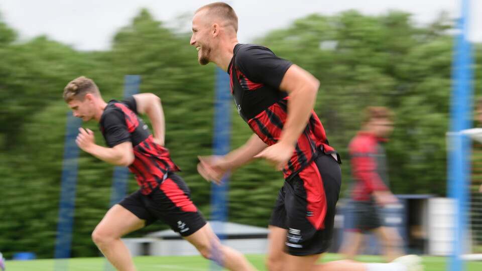 Players running with trees in the background