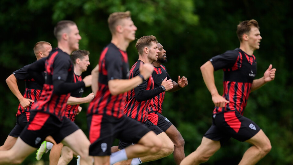 A group of men take part in a running drill.