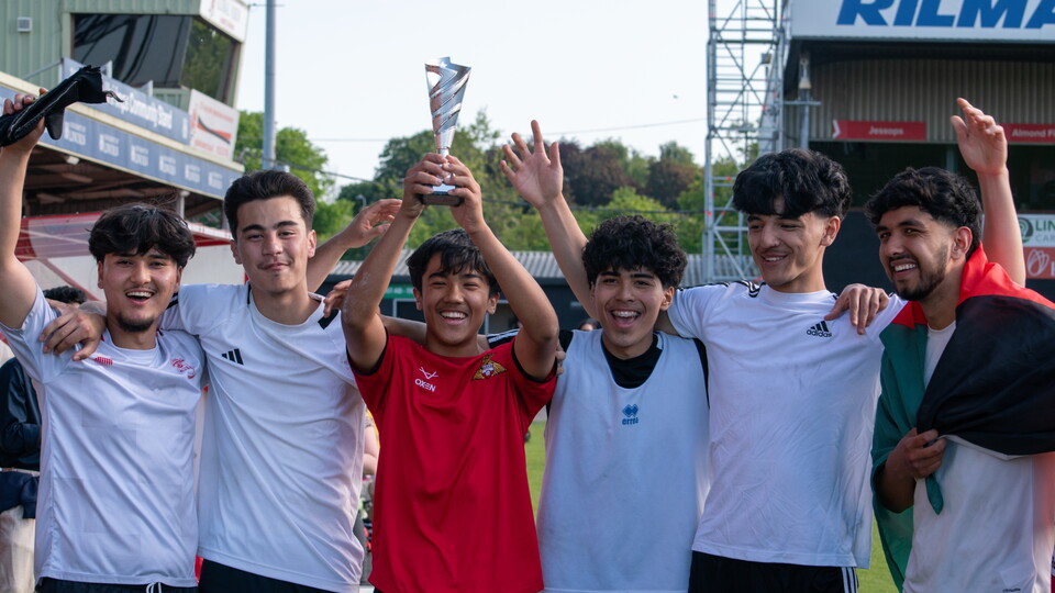 A picture of the Community World Cup winners celebrating with the trophy.