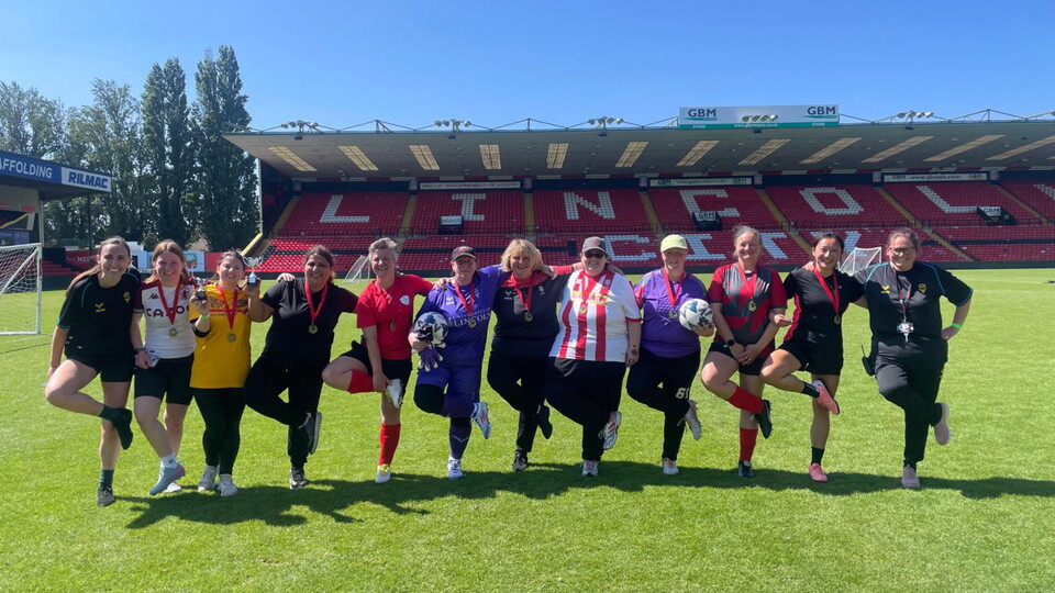 A group photograph of participants in the women's taster session at the LNER Stadium.