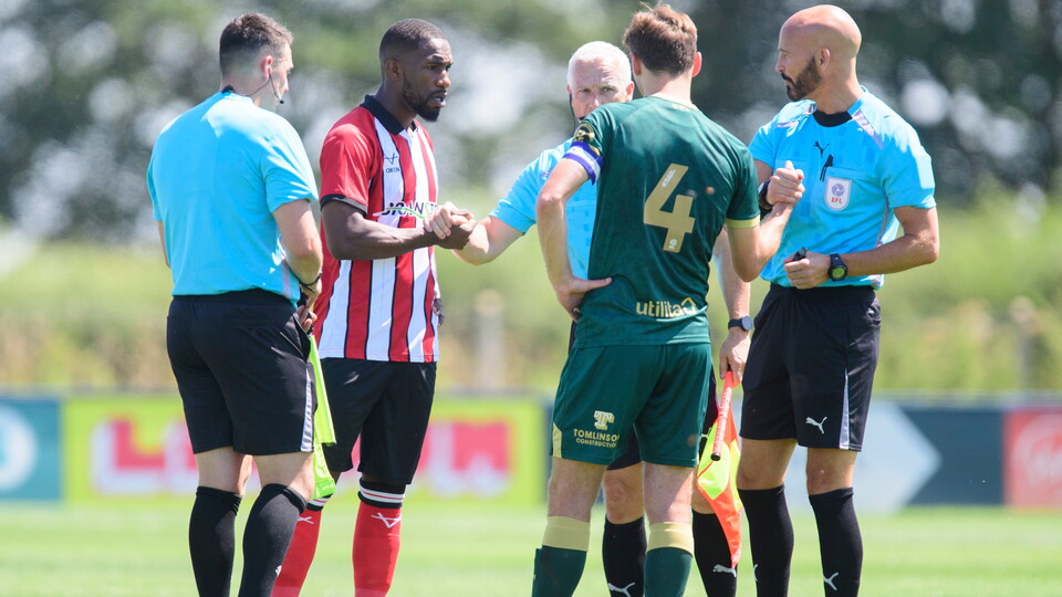 Lincoln City and Huddersfield captains and match officials stand together before the game.
