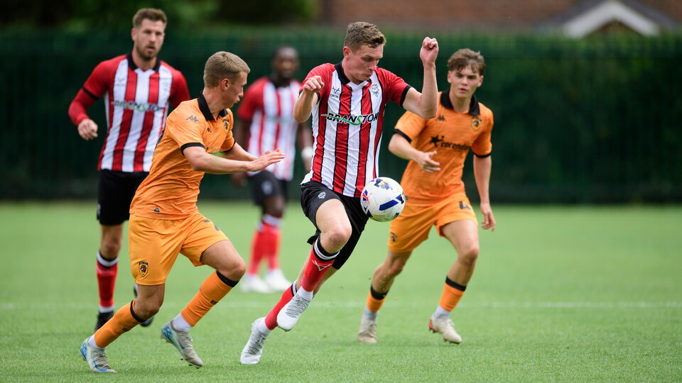 The ball bounces in front of Ethan Hamilton as he tries to run away from  a Hull City player