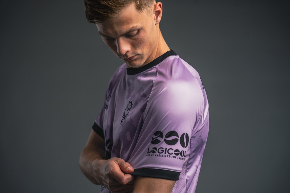 Erik Ring pulls the sleeve of a shirt revealing a Logicool logo