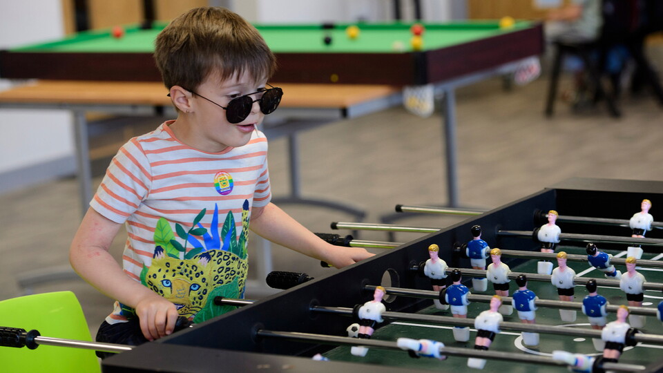 A junior fan plays table football in Poacher's Den