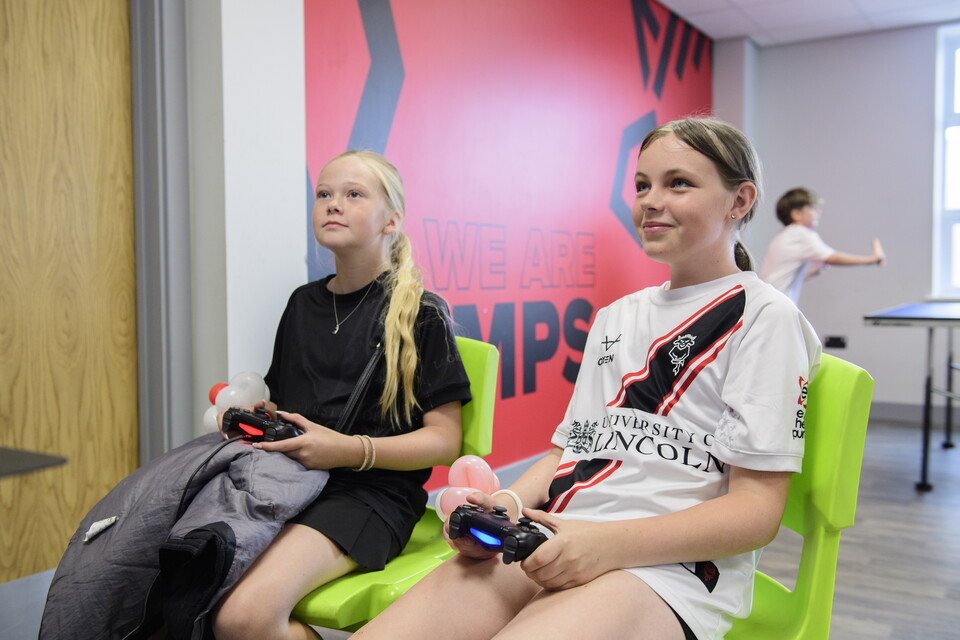 Two girls playing on a computer game.