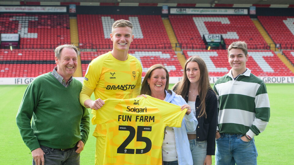 George Wickens of Lincoln City presents a shirt to representation of Lincoln City commercial partners Fun Farm following the EFL Sky Bet League One match between Lincoln City and Reading at LNER Stadium, Lincoln.