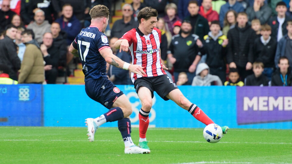 Adam Reach of Lincoln City crosses the ball despite the attentions of Jasper Pattenden of Stevenage during the EFL Sky Bet League One match between Lincoln City and Stevenage at LNER Stadium, Lincoln.