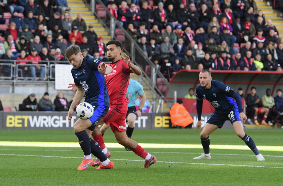Conor McGrandles controls the ball under pressure from a Leyton Orient player