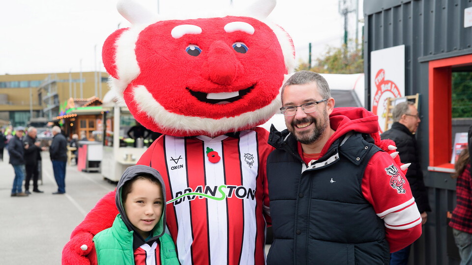 A pair of City fans with Poacher the Imp outside the LNER Stadium