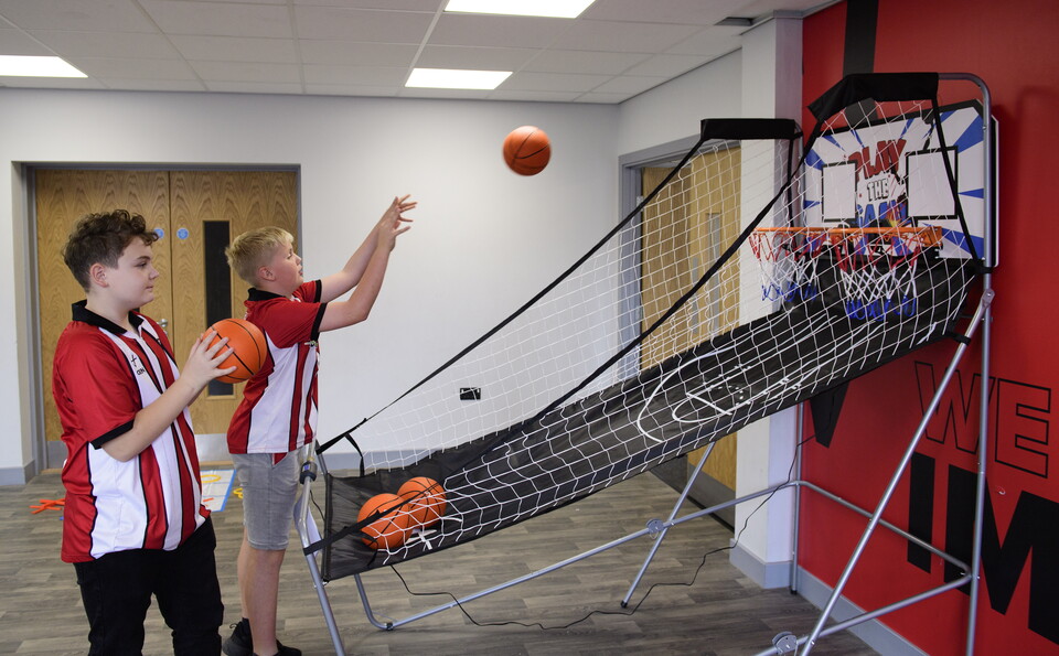 Two boys play basketball